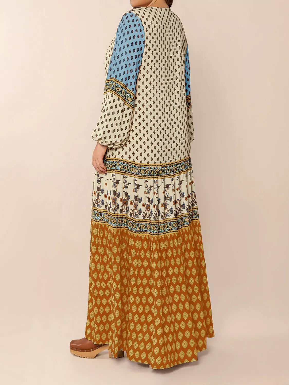 Woman wearing a bohemian patchwork maxi dress in ivory, blue, and rust tones – flowy tiered boho style from A Whimsical Affair.