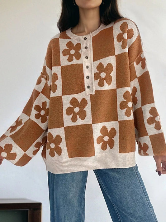 Brown and cream checkerboard henley sweater with daisy floral pattern on model with jeans