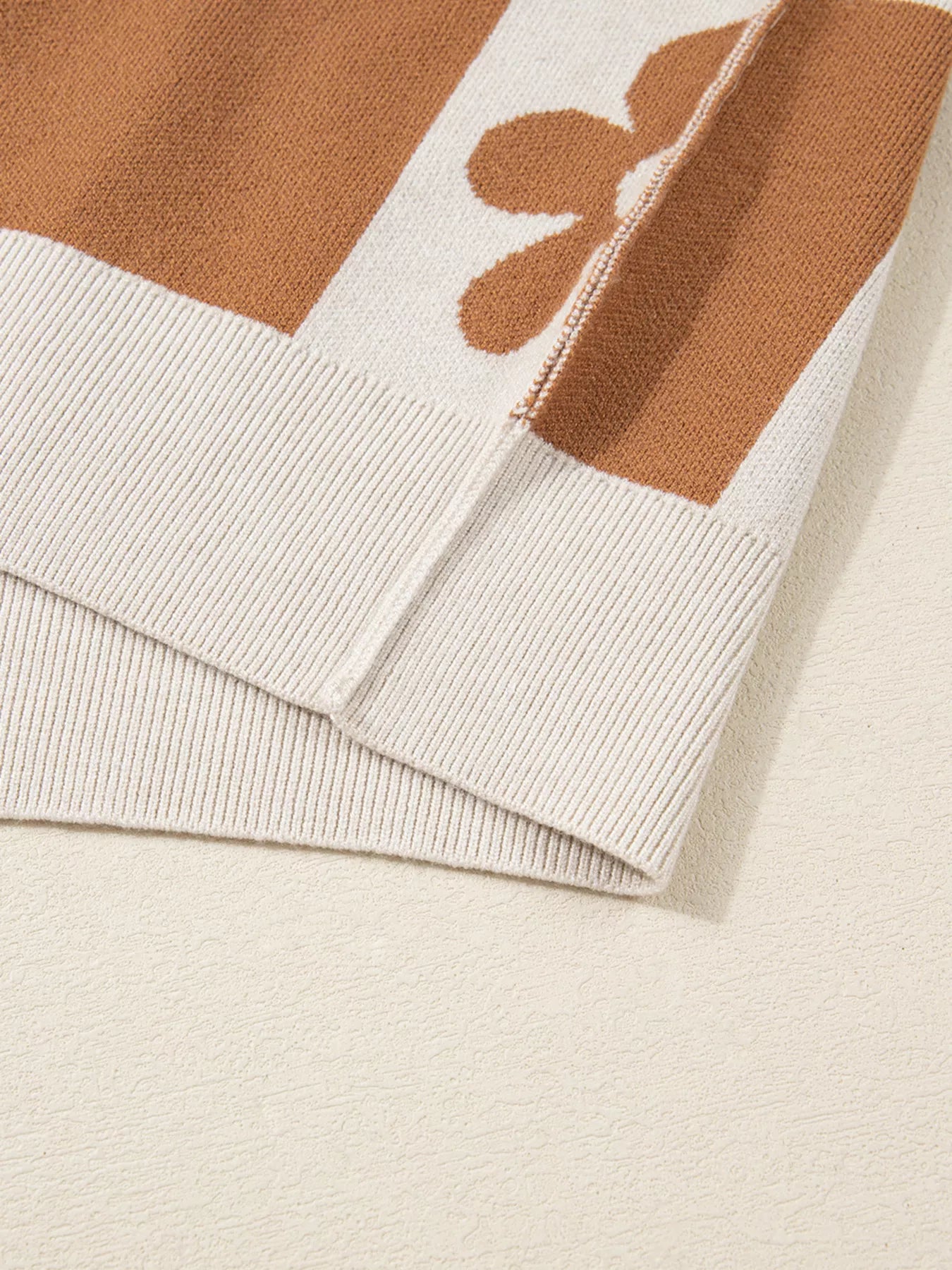 Brown and cream checkerboard henley sweater with daisy floral pattern