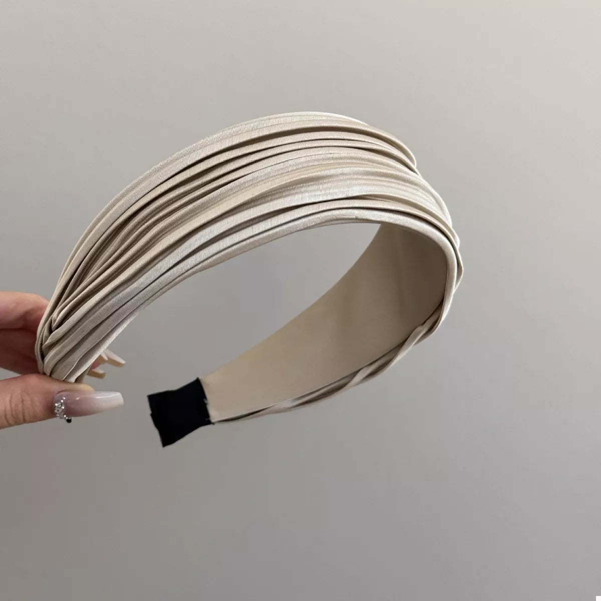 Woman holding the Everyday Elegance Pleated Headband in Black