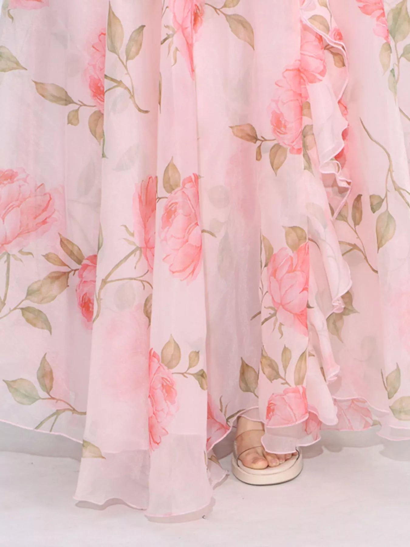 Pink floral tiered gown with ruffled details, puff sleeves, and rose appliqué accents.