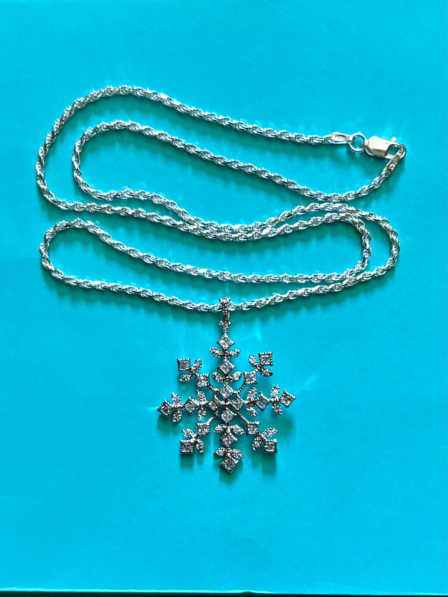 Sterling silver snowflake pendant necklace from the Enchanted Crystals Collection, worn on a matching silver chain.