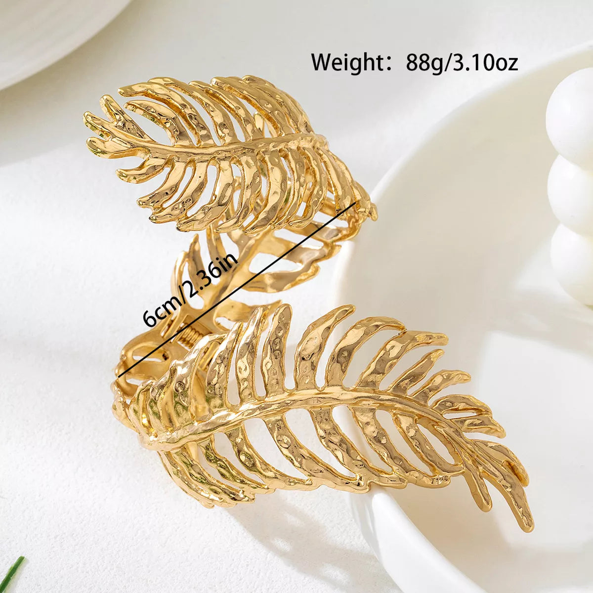 18K gold-plated palm leaf cuff bracelet with hammered texture, worn on wrist — elegant boho statement jewelry from A Whimsical Affair.
