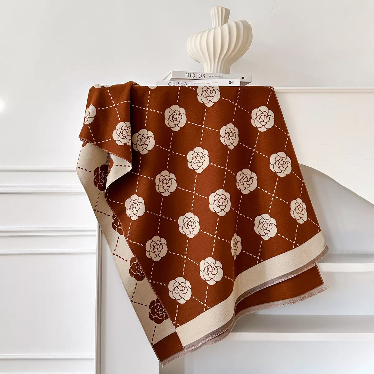 Floral wrap scarf with elegant geometric pattern draped over a neutral coat