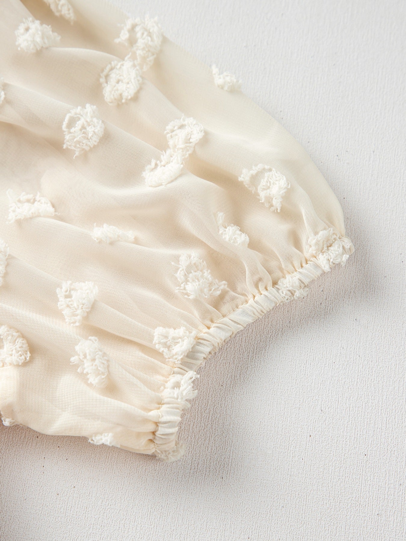 Ivory textured blouse with sheer puff sleeves and dotted detail