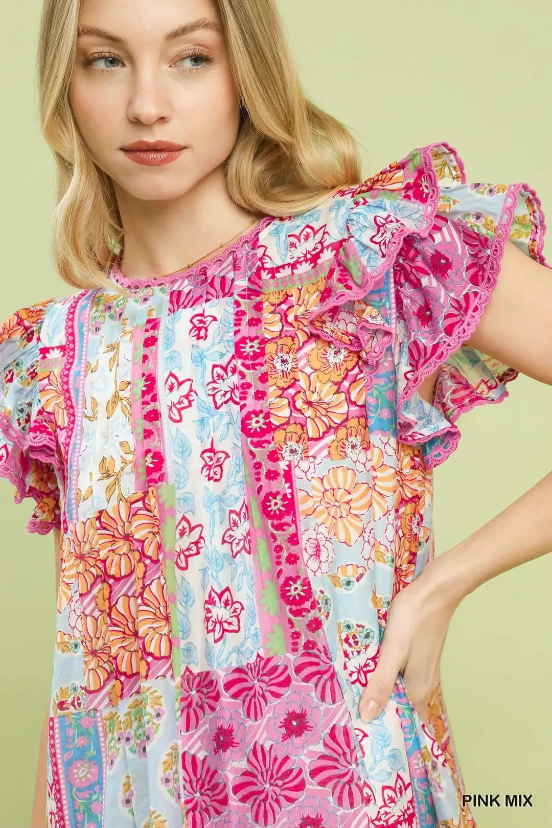 Colorful patchwork mini dress with ruffled flutter sleeves, lined body, floral prints, and breezy boho-inspired style.