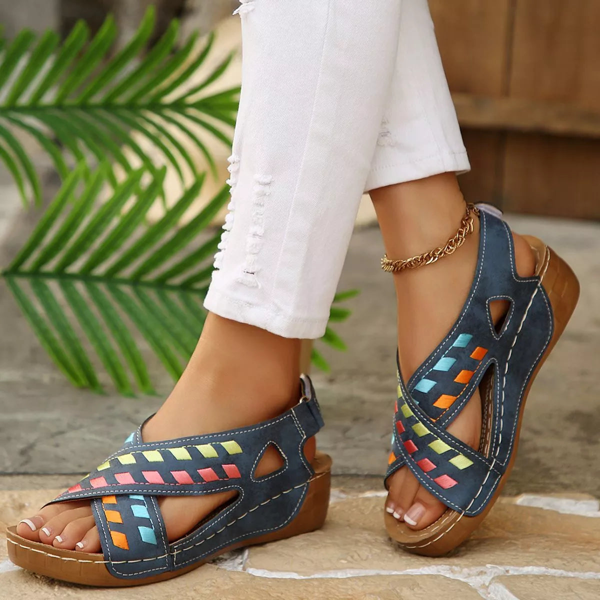 Blue boho mid heel sandals with colorful woven-style accents, cutout details, contrast stitching, and brown sole.