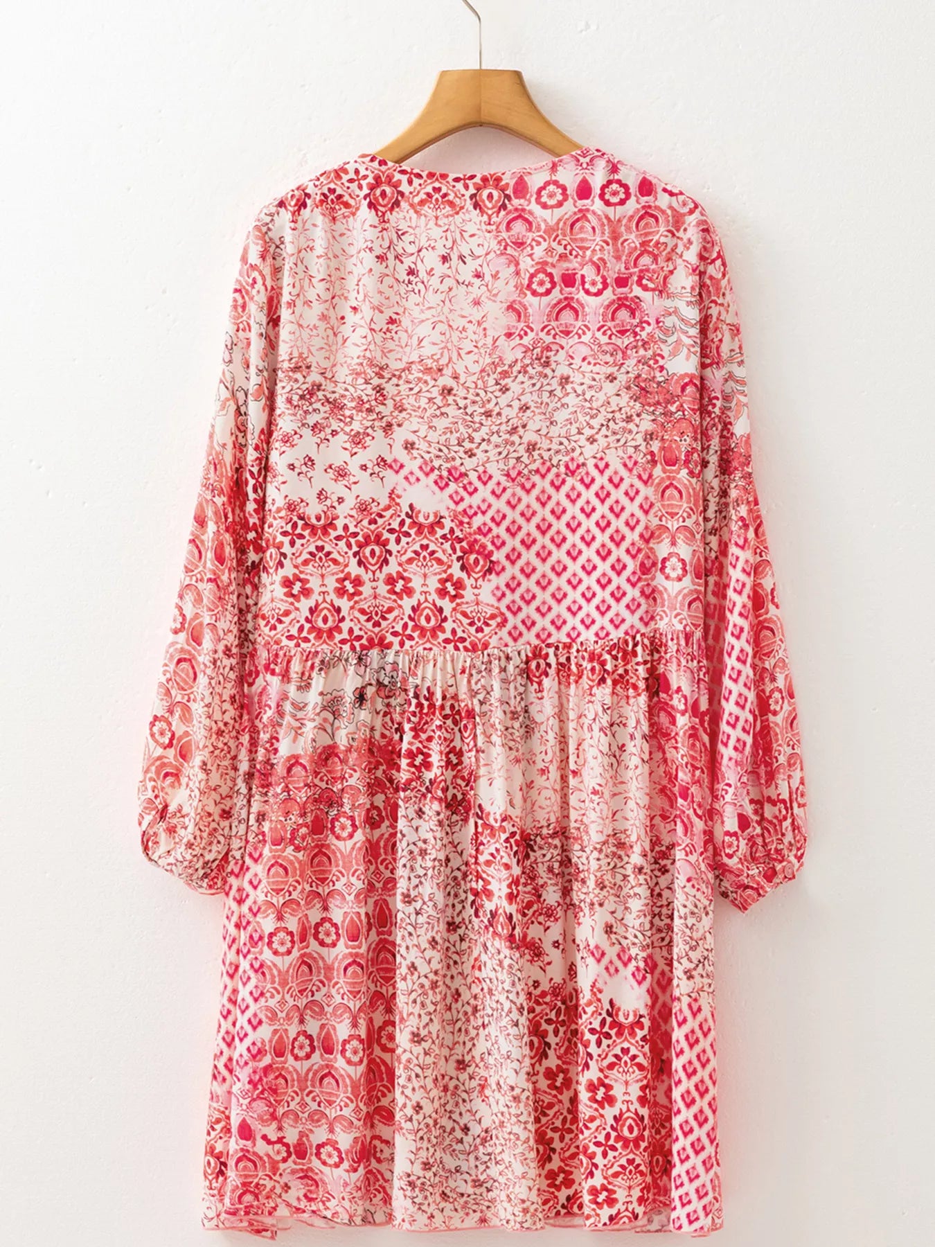 Rosé Reverie Mini Dress – flowy floral print boho dress with tassel tie neckline and ruffle details.