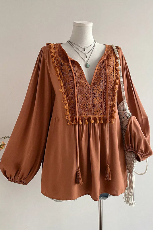Rustic boho blouse with embroidered front detail, tassel trim, tied neckline, flowy long sleeves, and slightly stretchy fabric.