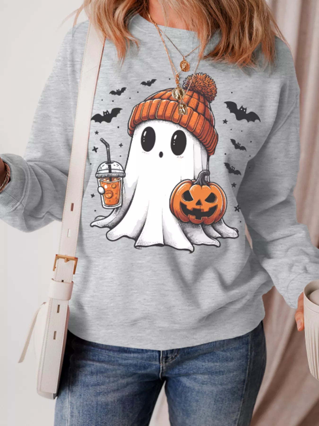 Gray sweatshirt with ghost in orange beanie holding coffee and jack-o’-lantern, surrounded by bats – Sippin’ Spooky style from A Whimsical Affair.