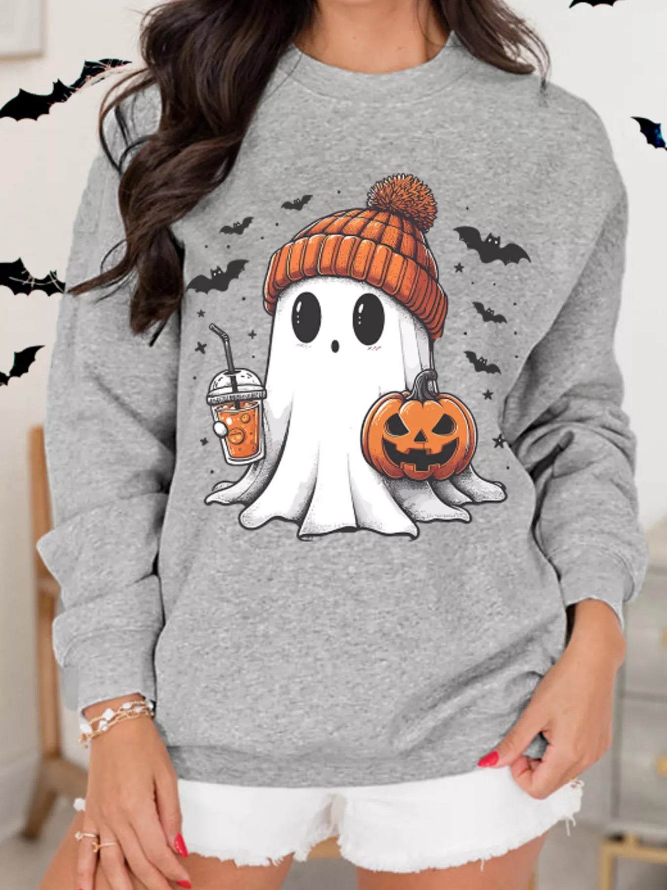 Gray sweatshirt with ghost in orange beanie holding coffee and jack-o’-lantern, surrounded by bats – Sippin’ Spooky style from A Whimsical Affair.