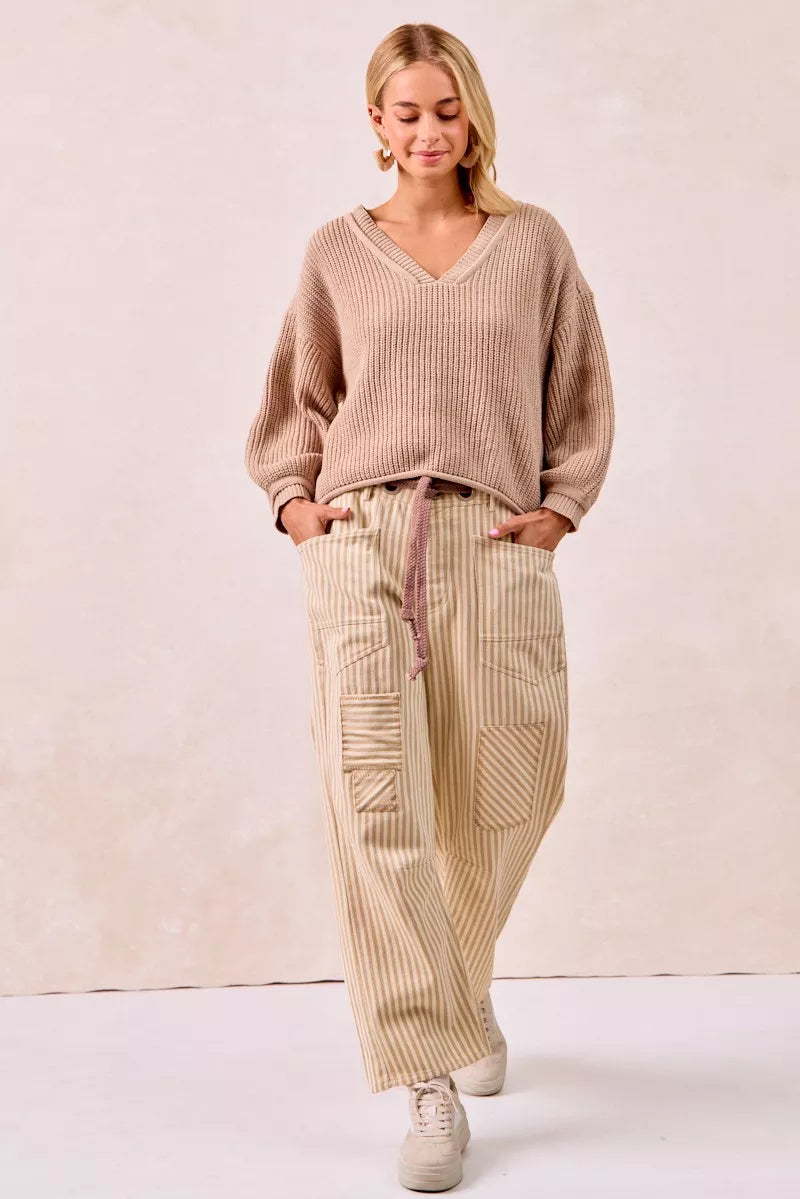Beige and cream striped barrel leg pants with drawstring waist and patch pockets