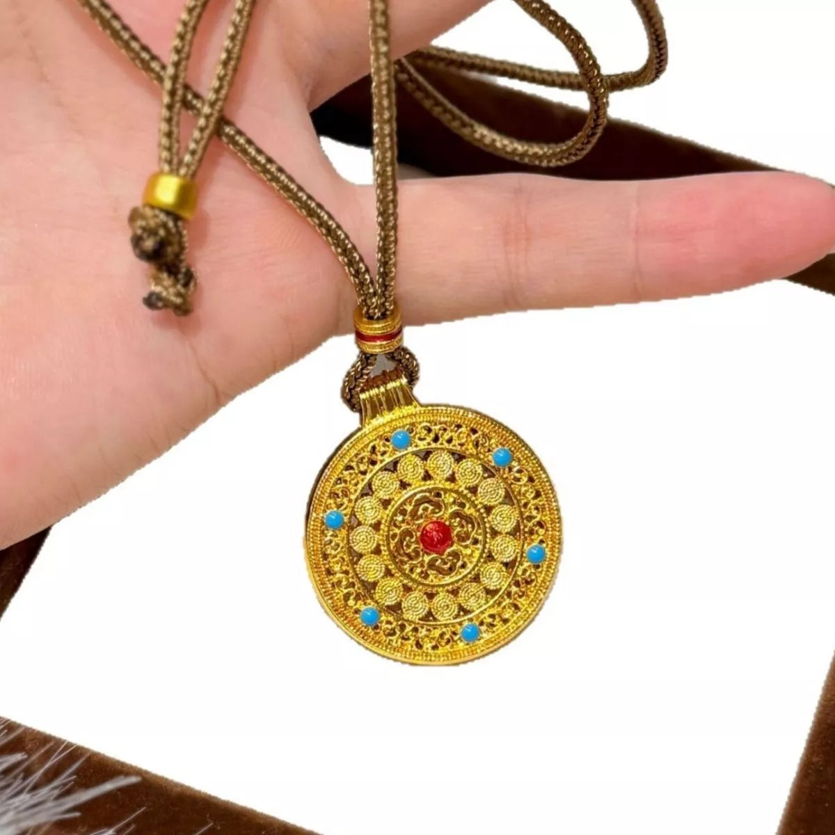 18K gold-plated medallion necklace with ornate circular design, zircon accents, and colorful red and turquoise details.