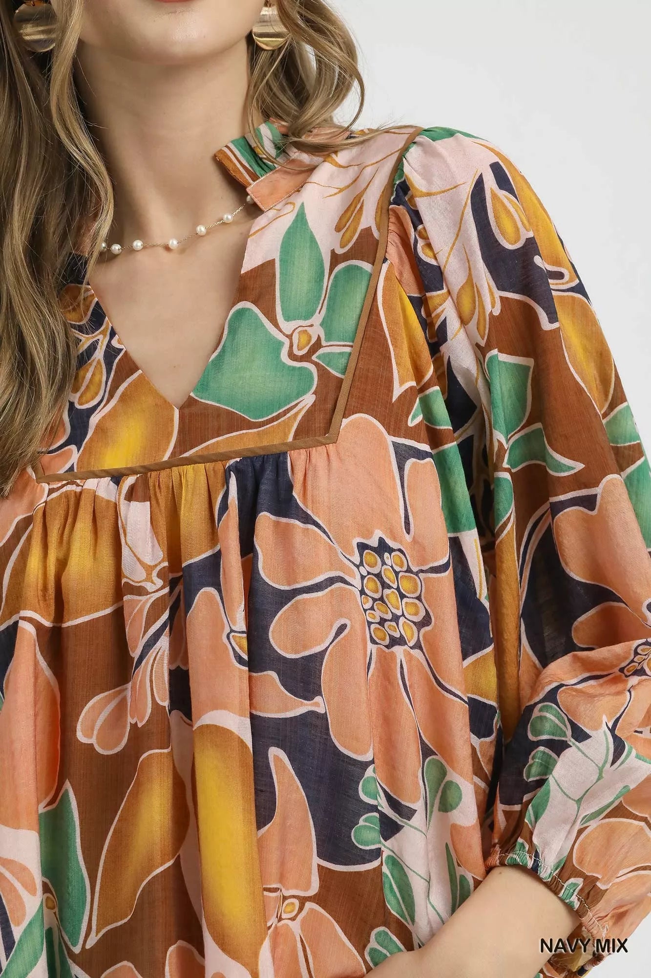 Multicolor abstract floral print blouse with ruffle neck and long sleeves.
