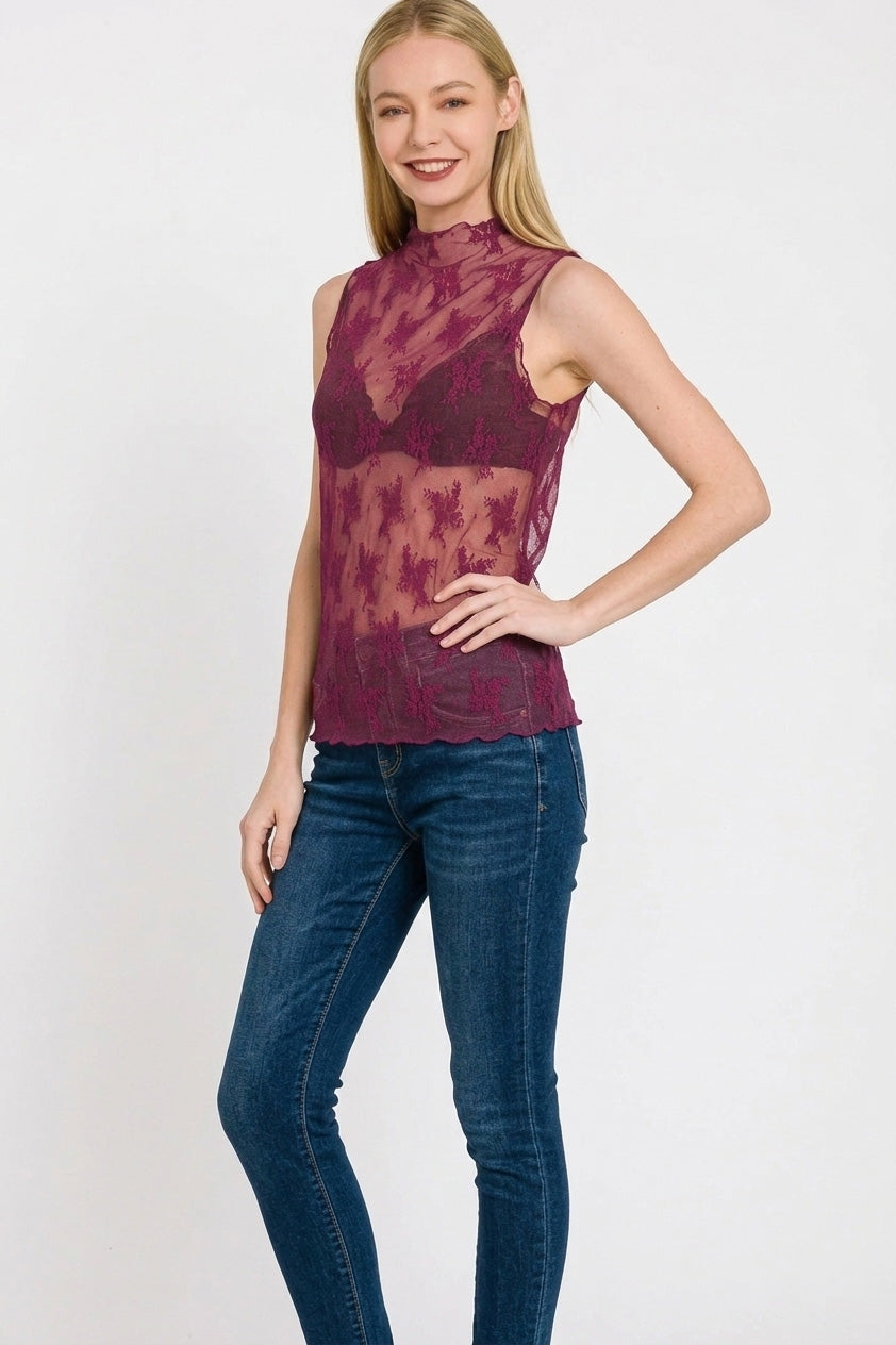 Woman wearing a sheer floral lace mock neck sleeveless tank in rich berry tone