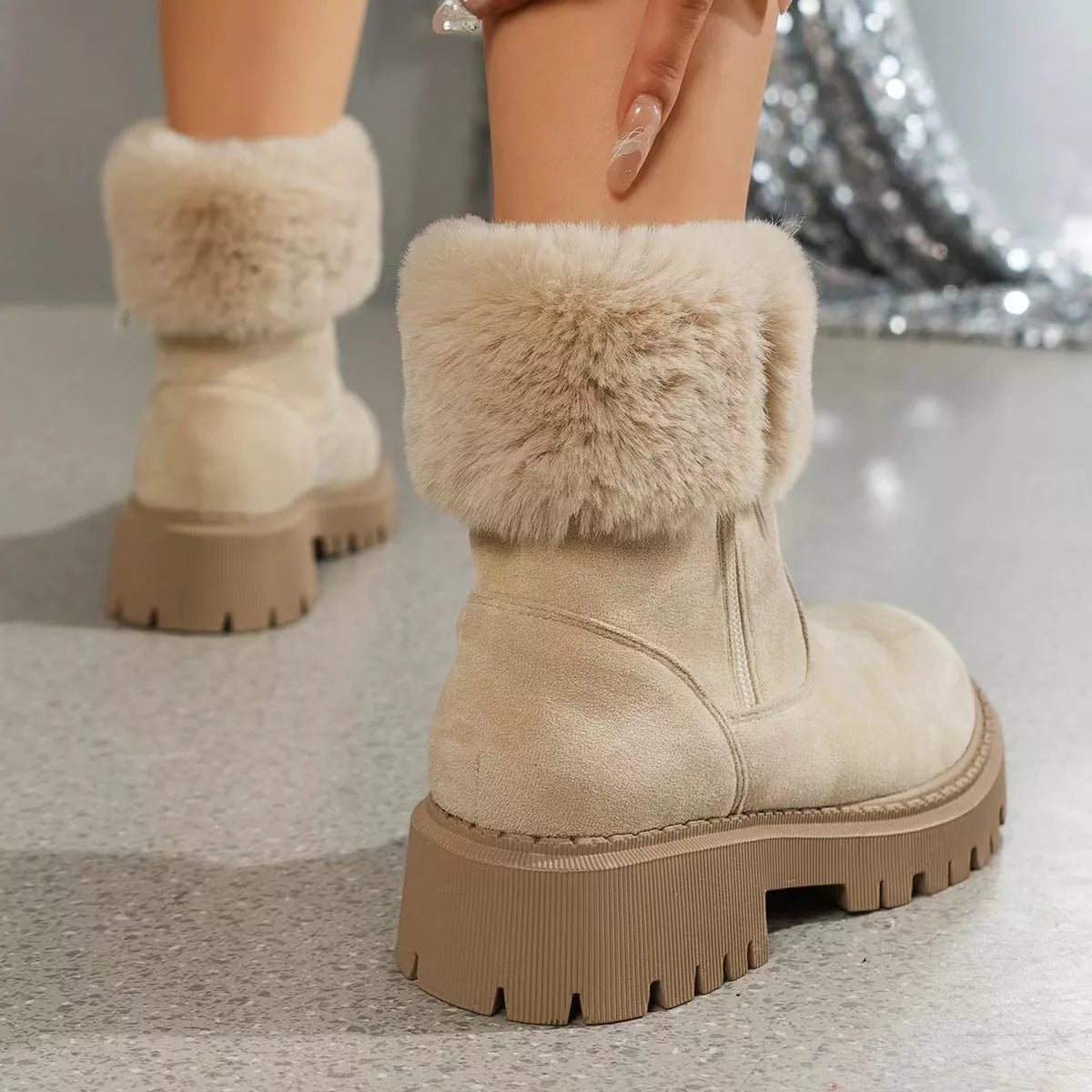 Women’s suede winter boots with plush fur cuff detail and mid-height rubber sole.