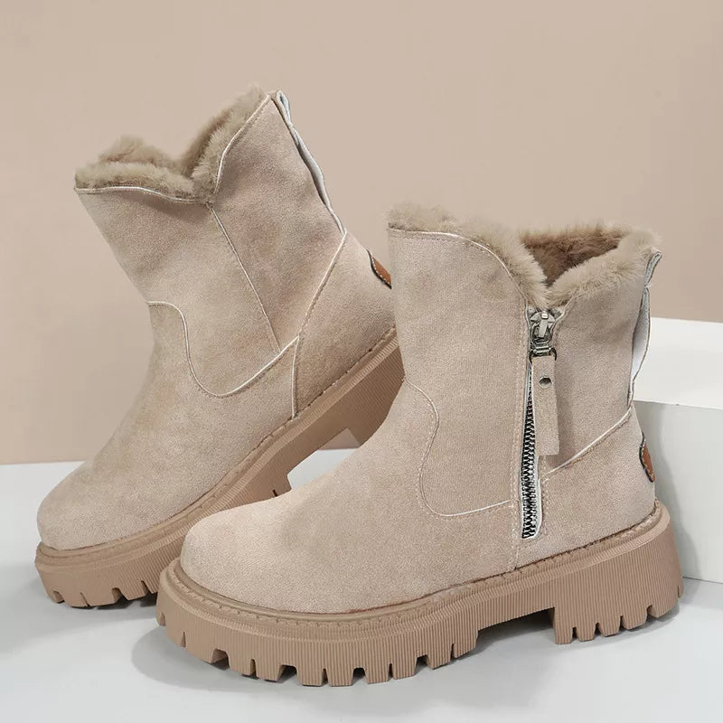 Women’s suede winter boots with plush fur cuff detail and mid-height rubber sole.
