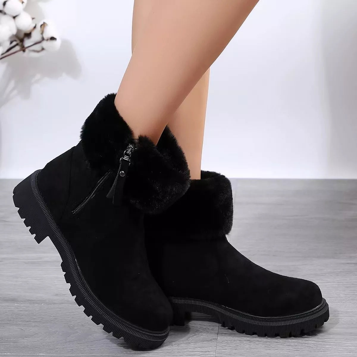 Women’s suede winter boots with plush fur cuff detail and mid-height rubber sole.