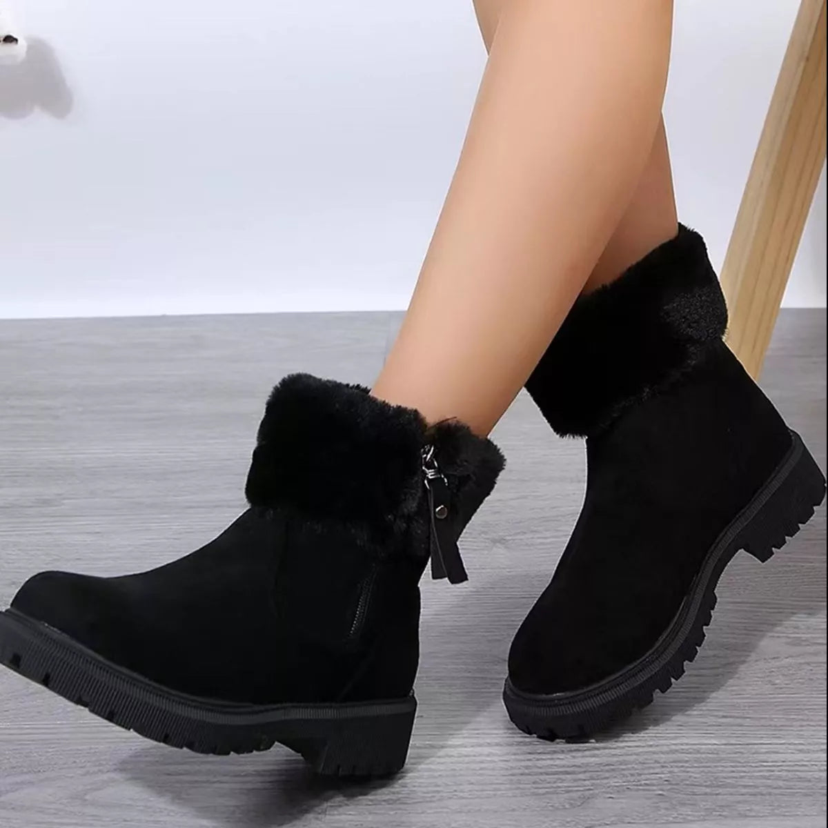 Women’s suede winter boots with plush fur cuff detail and mid-height rubber sole.