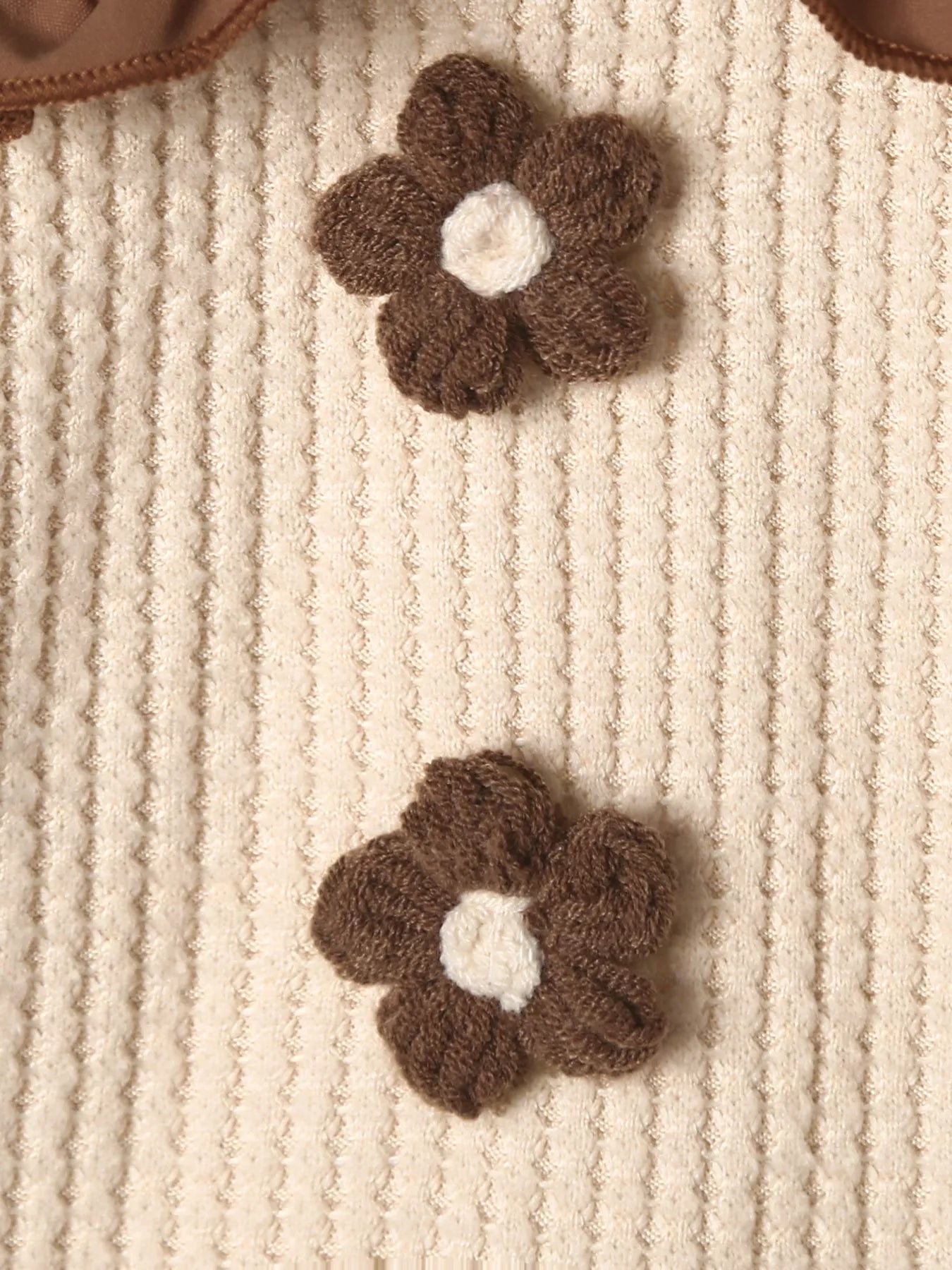 Beige and brown toddler floral knit top and pants set hanging on display