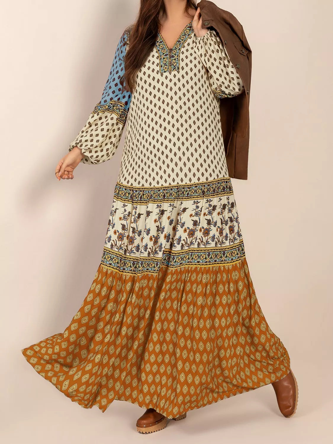 Woman wearing a bohemian patchwork maxi dress in ivory, blue, and rust tones – flowy tiered boho style from A Whimsical Affair.