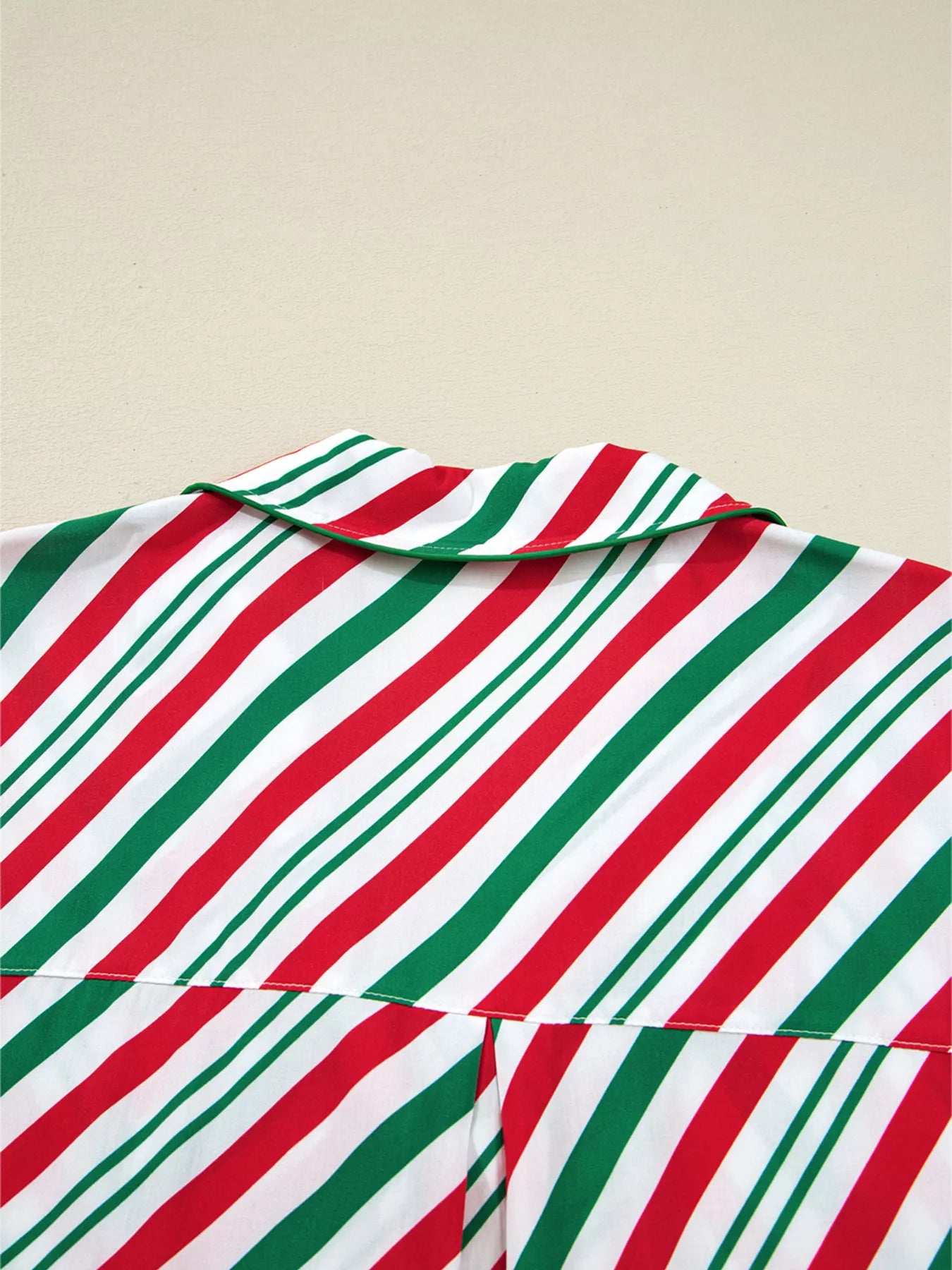 Festive striped two-piece pajama set with velvet waist tie and long sleeves.