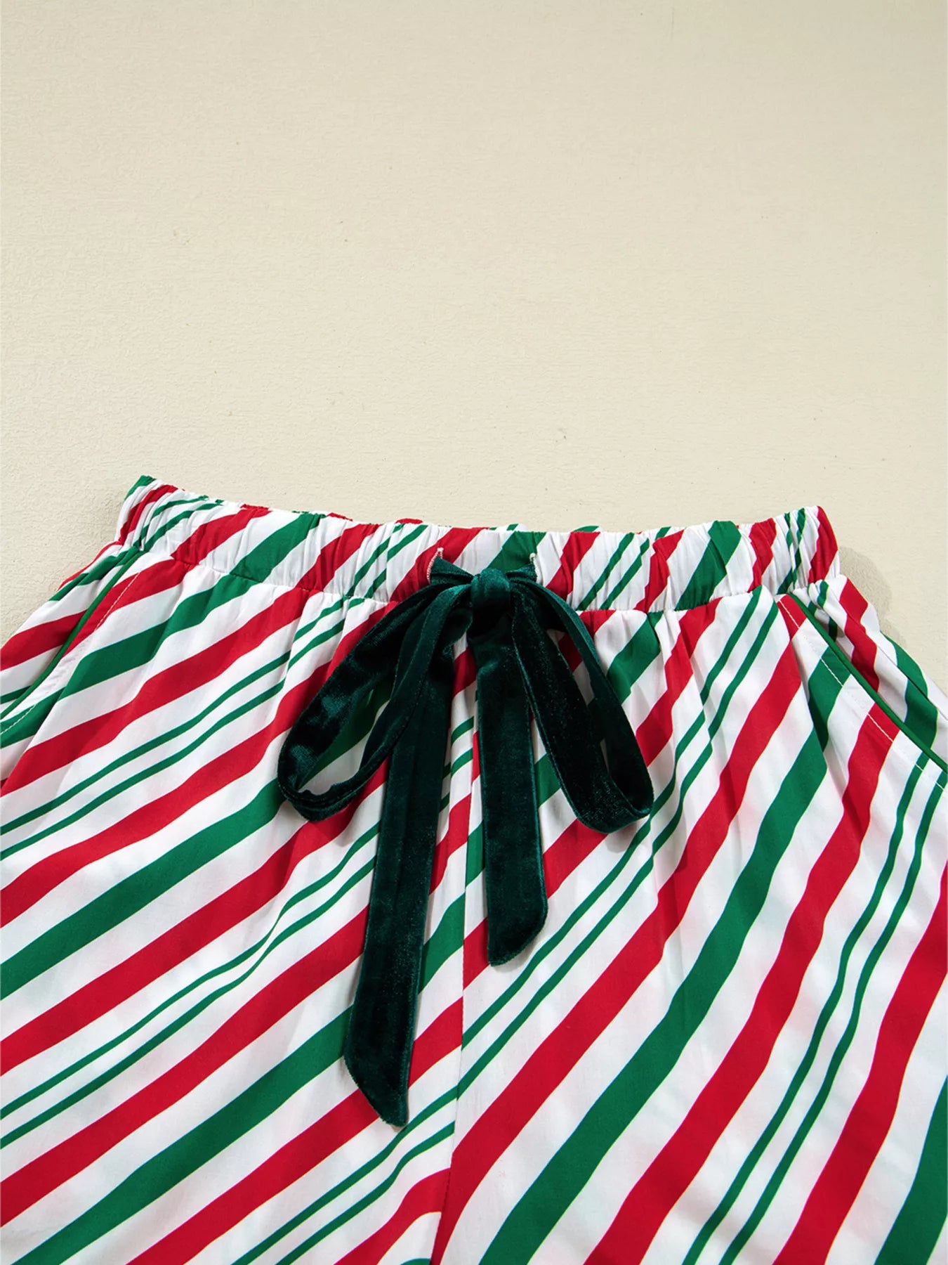 Festive striped two-piece pajama set with velvet waist tie and long sleeves.