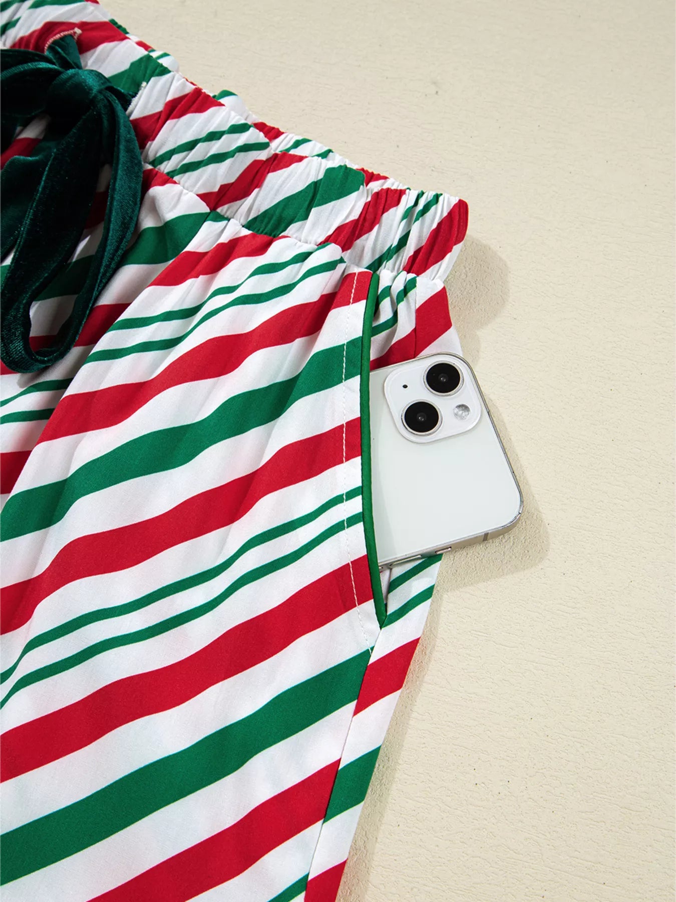 Festive striped two-piece pajama set with velvet waist tie and long sleeves.