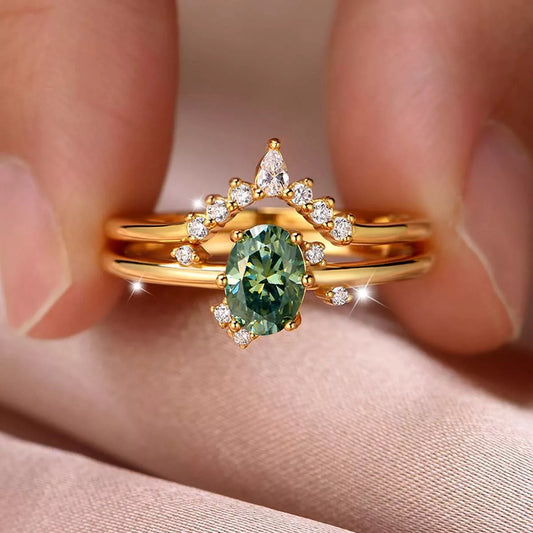 Close-up of gold moissanite ring set featuring green oval stone and crown band with zircon accents – elegant celestial jewelry from A Whimsical Affair.