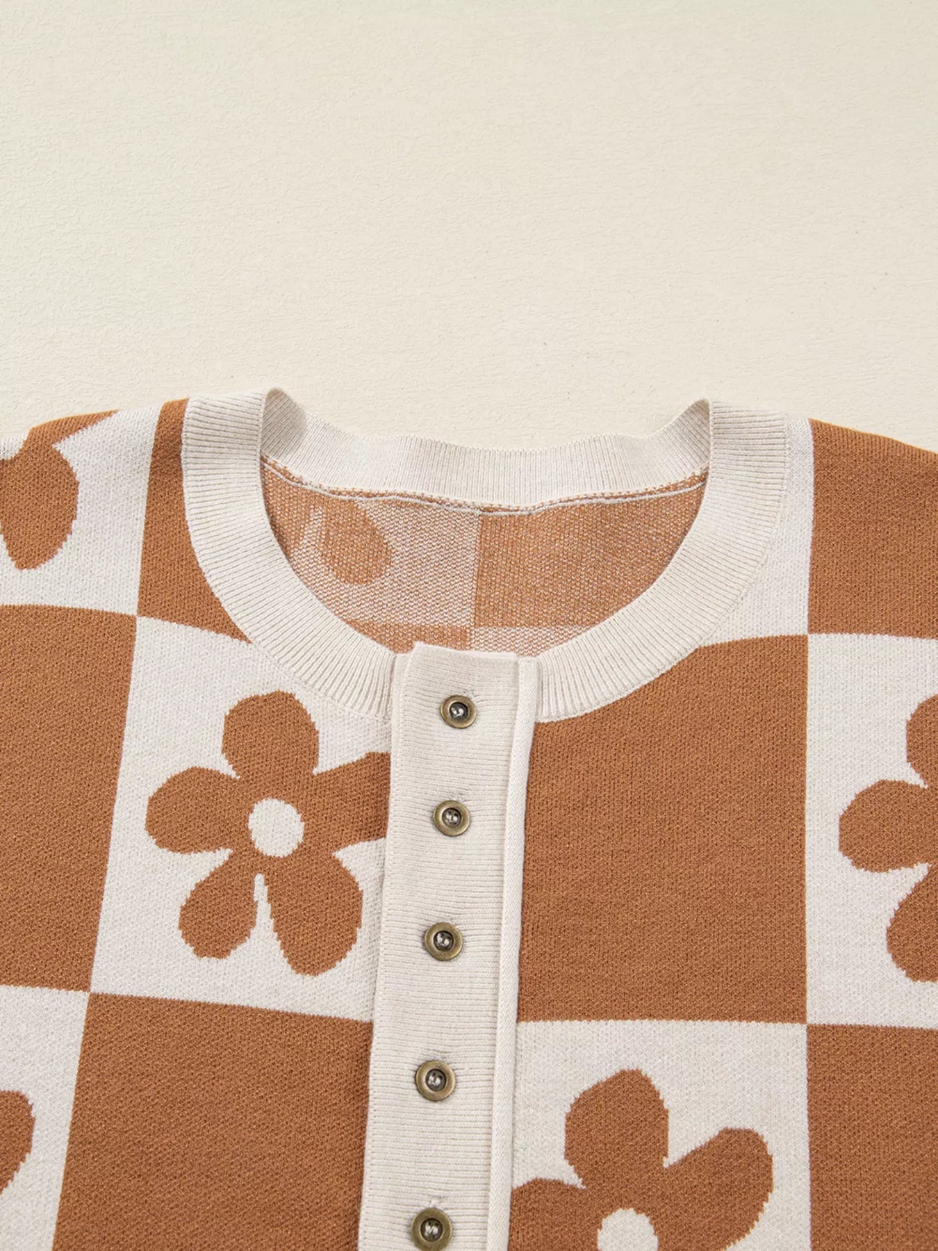 Brown and cream checkerboard henley sweater with daisy floral pattern
