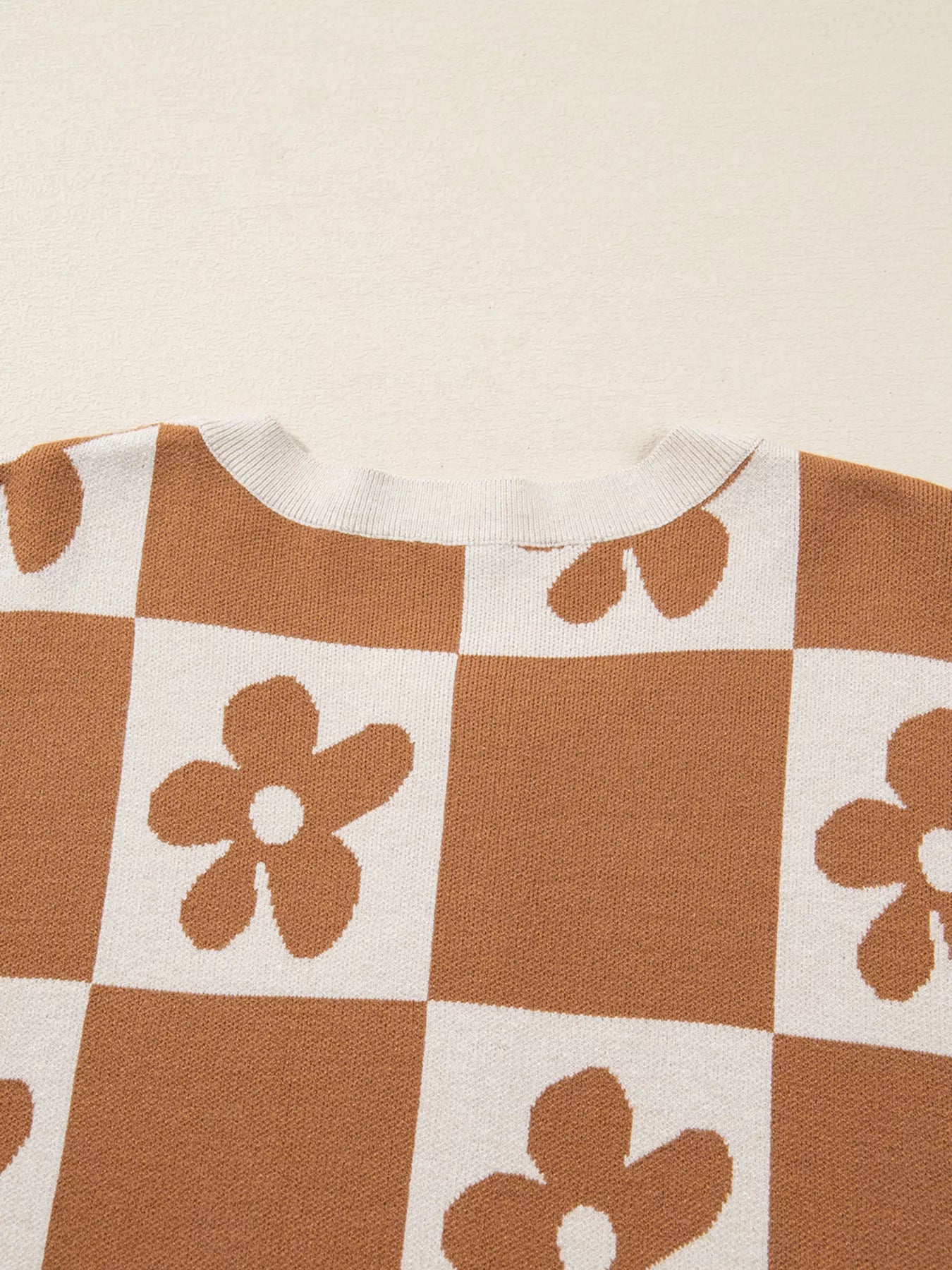 Brown and cream checkerboard henley sweater with daisy floral pattern