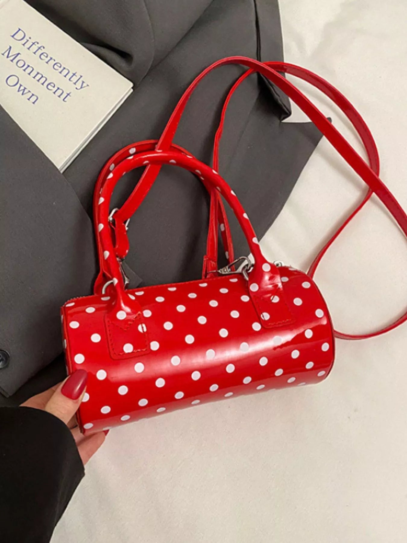 Cherry red mini purse with detachable strap and polka dot pattern.
