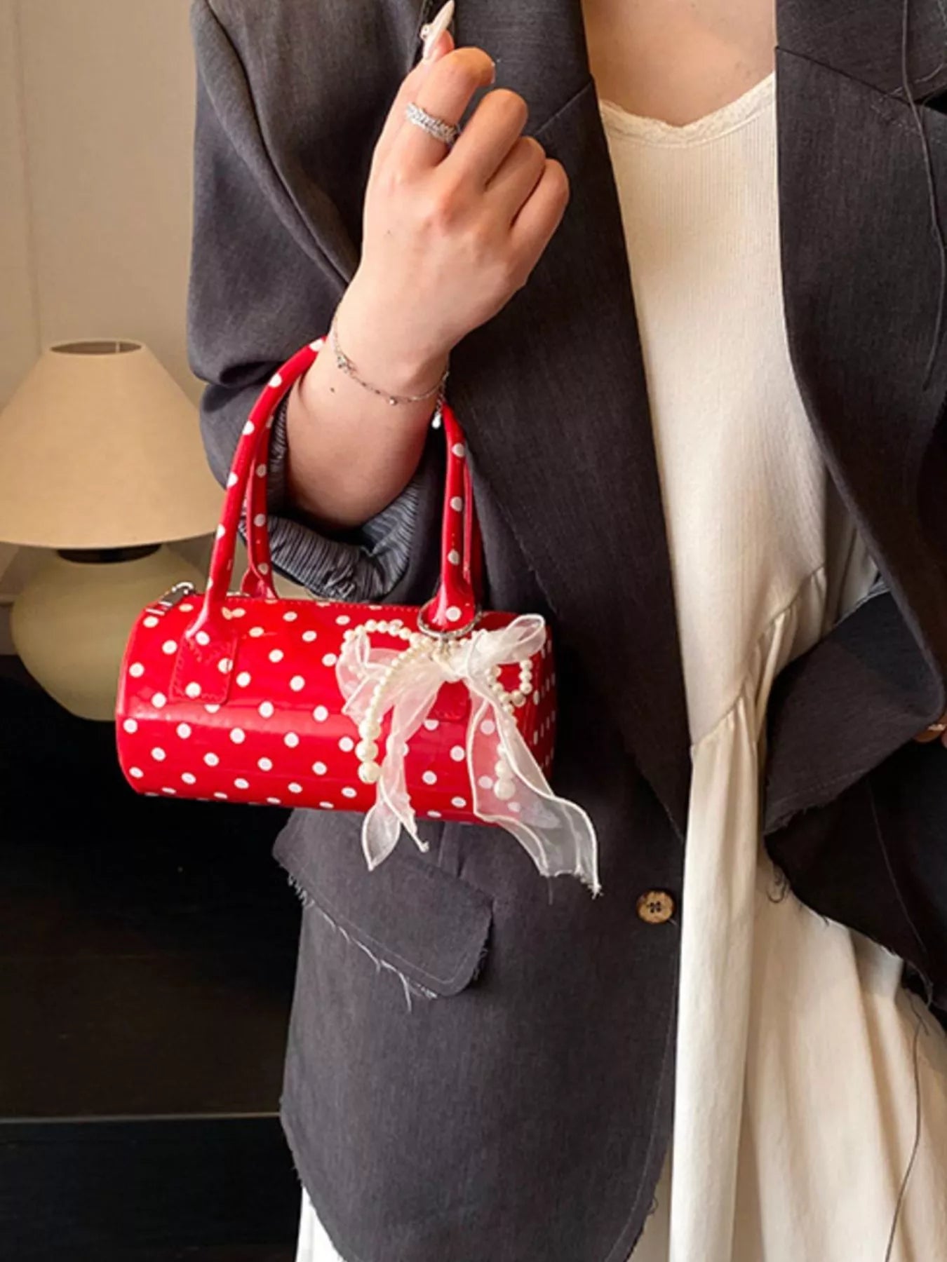 Cherry red mini purse with detachable strap and polka dot pattern.