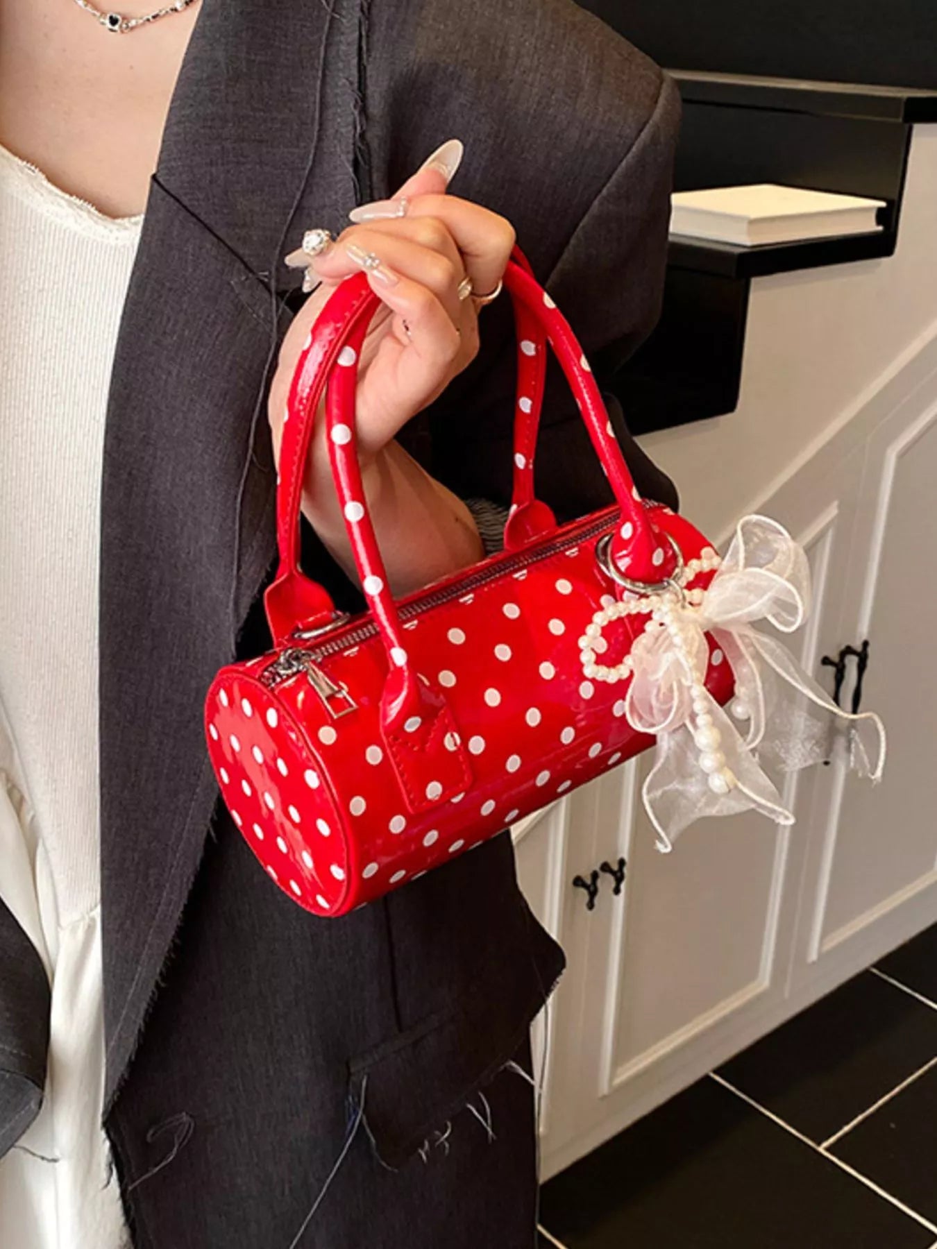 Cherry red mini purse with detachable strap and polka dot pattern.