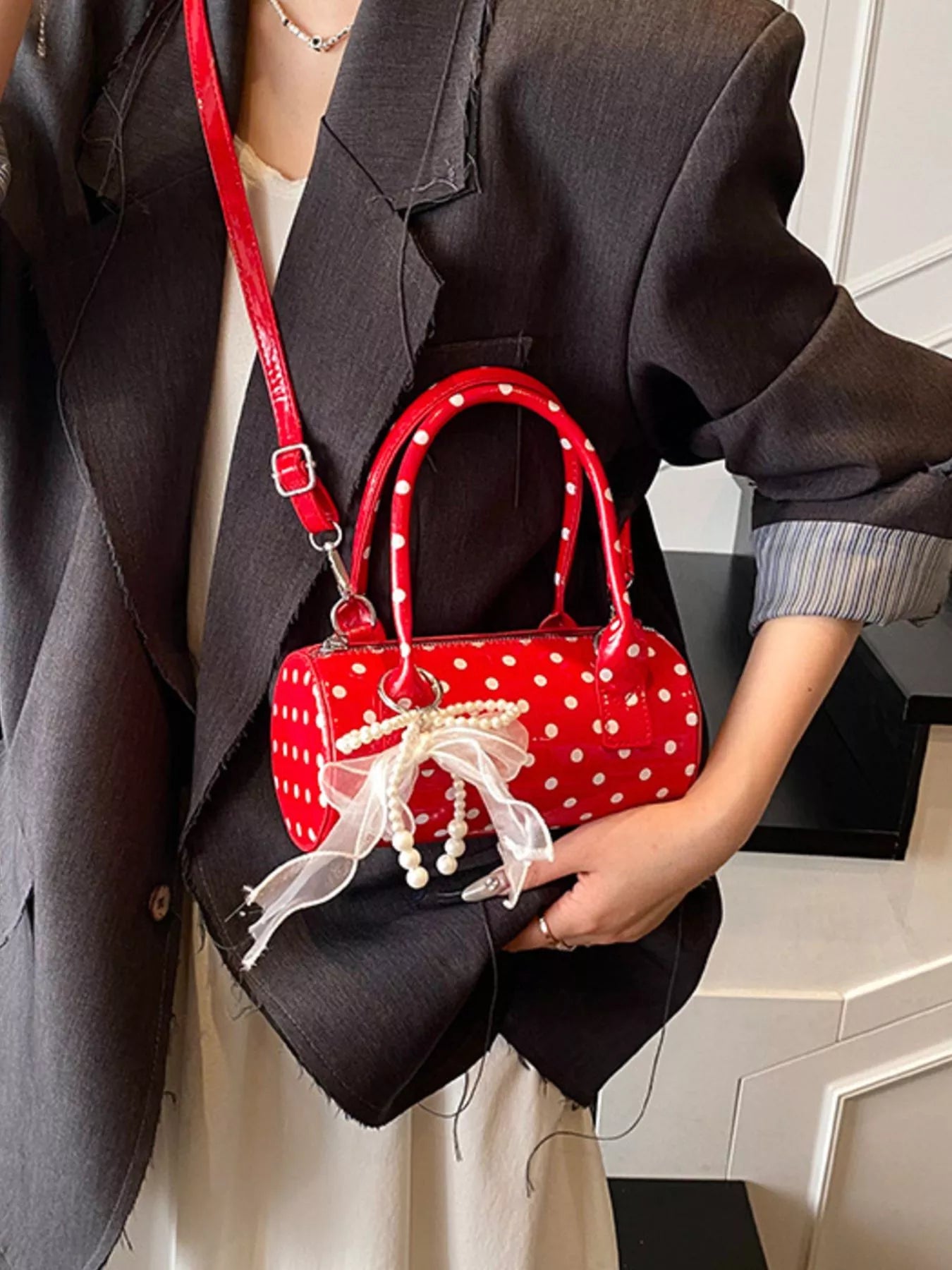 Cherry red mini purse with detachable strap and polka dot pattern.