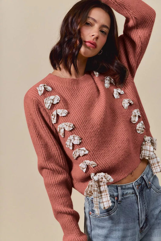 Woman wearing a rust ribbed knit sweater with plaid bows and side tie accents – cozy rustic fall fashion from A Whimsical Affair.