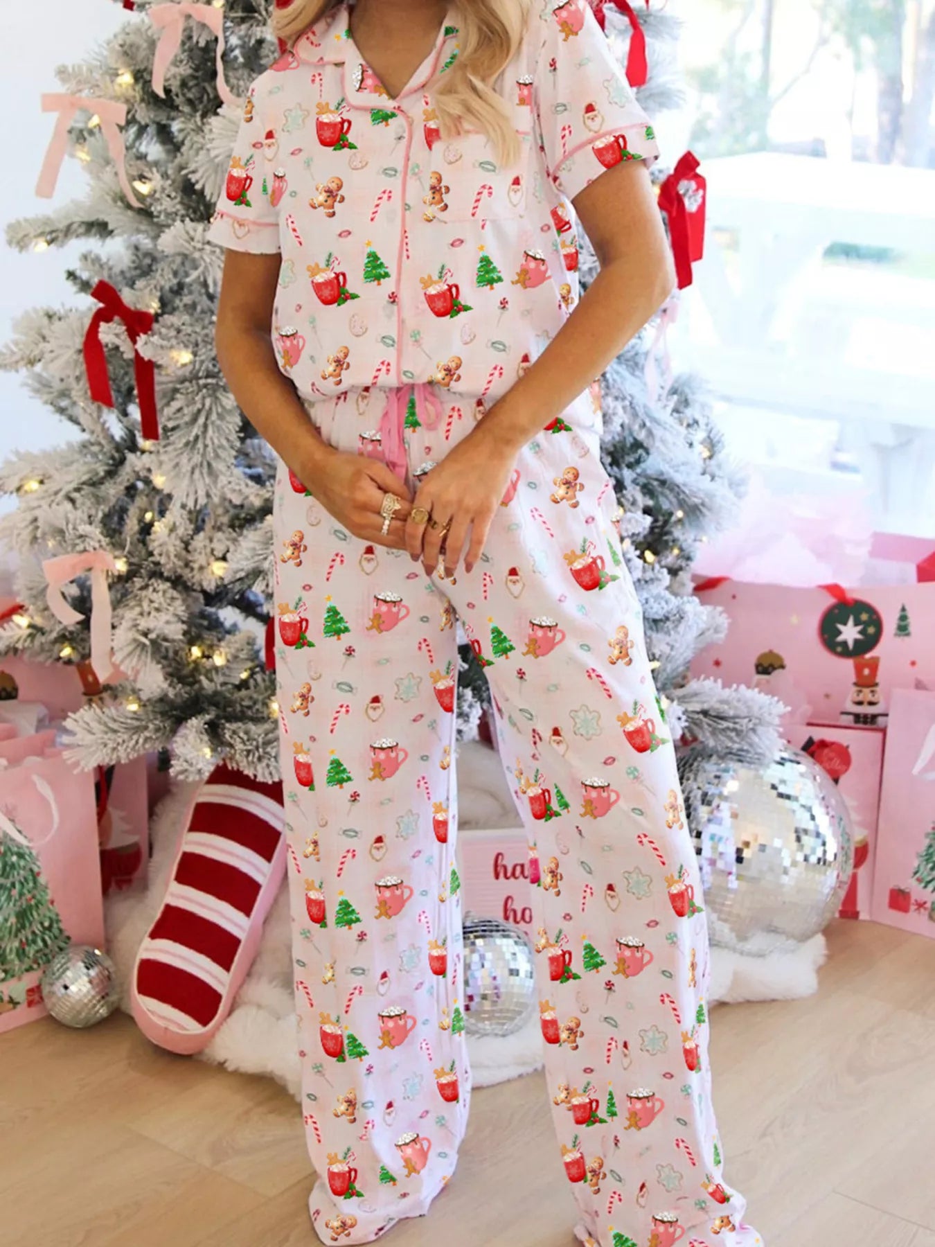 Close-up of holiday printed pajama pants featuring candy canes, cocoa mugs, gingerbread cookies, and Santa motifs.