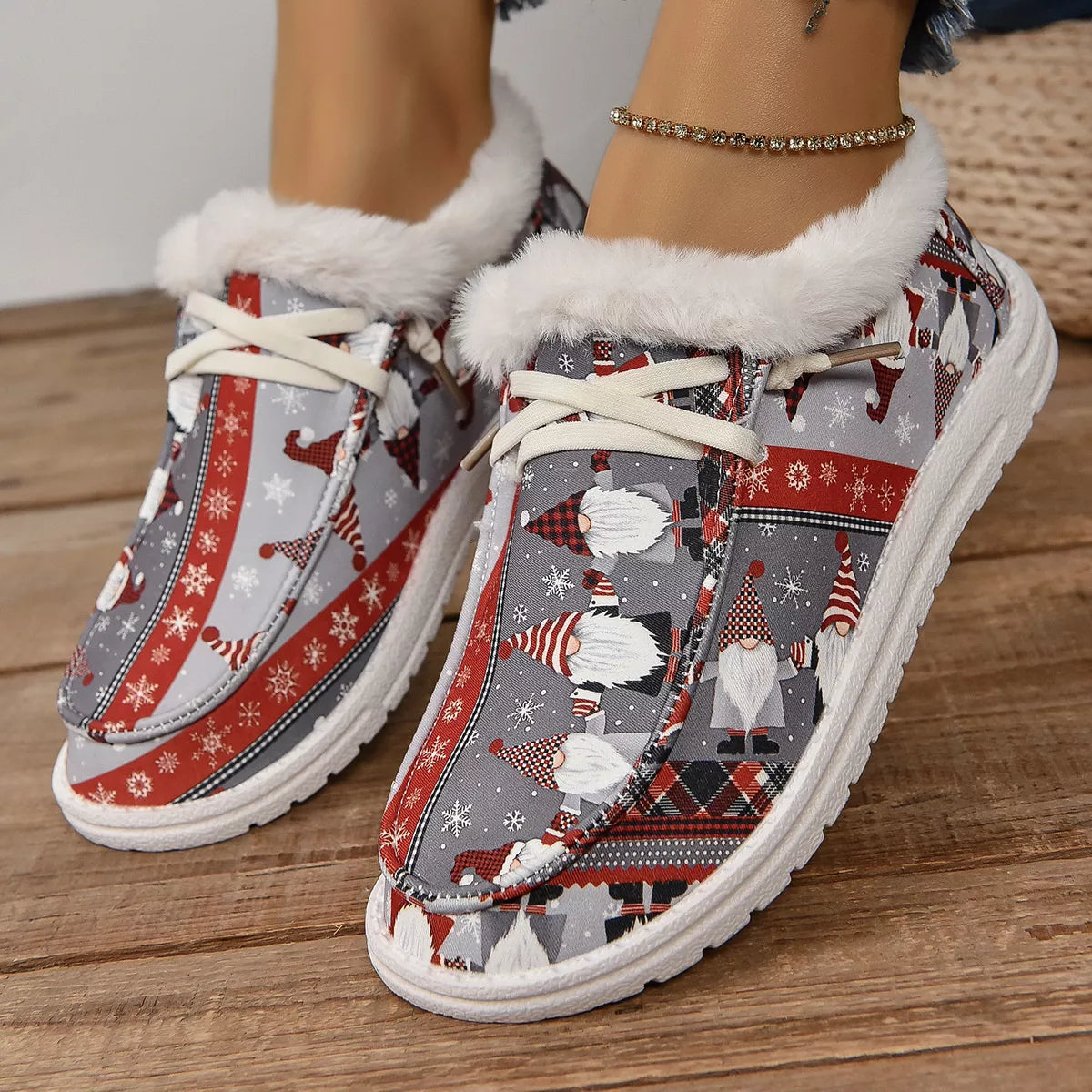 Close-up of gray and red Christmas gnome print loafers with white faux-fur lining worn with frayed hem jeans.