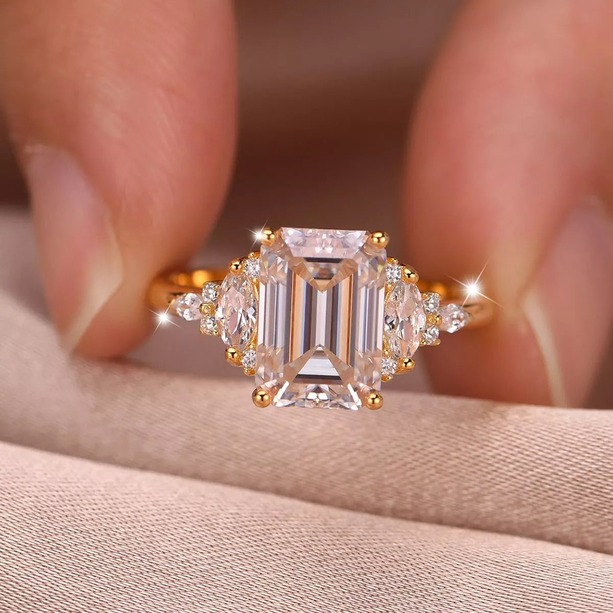 Close-up of emerald-cut moissanite ring with gold band and zircon accents — luxurious and elegant engagement ring from A Whimsical Affair.