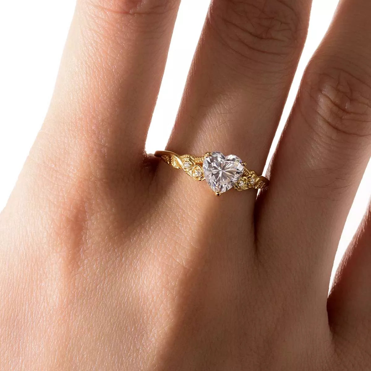Close-up of a gold heart-shaped moissanite ring with zircon accents — romantic fine jewelry piece from A Whimsical Affair.