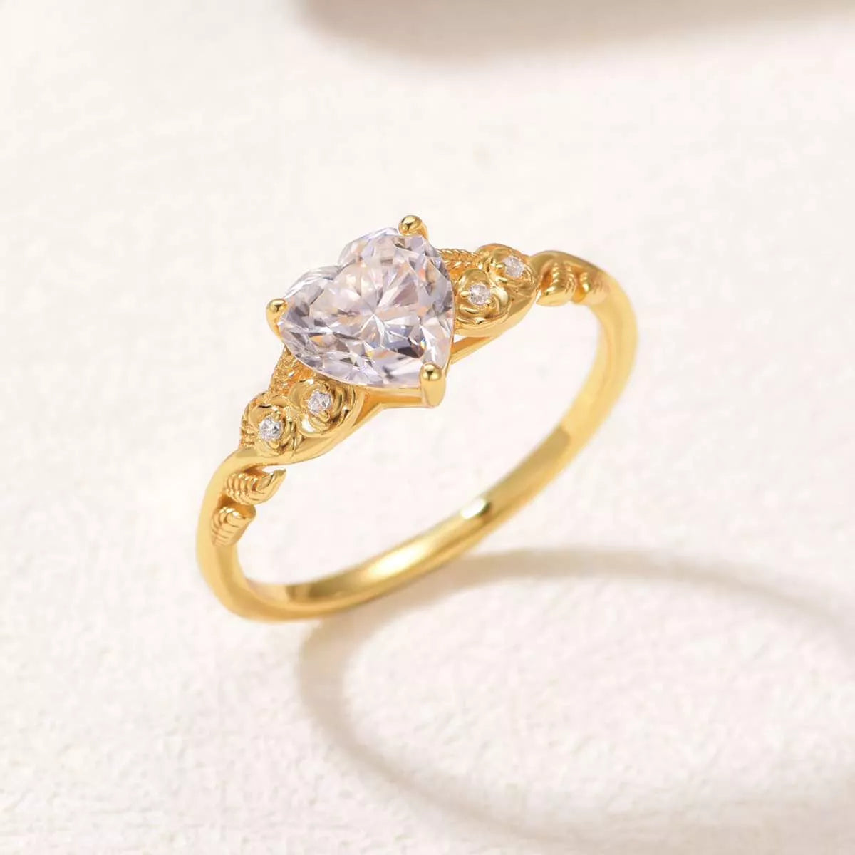 Close-up of a gold heart-shaped moissanite ring with zircon accents — romantic fine jewelry piece from A Whimsical Affair.