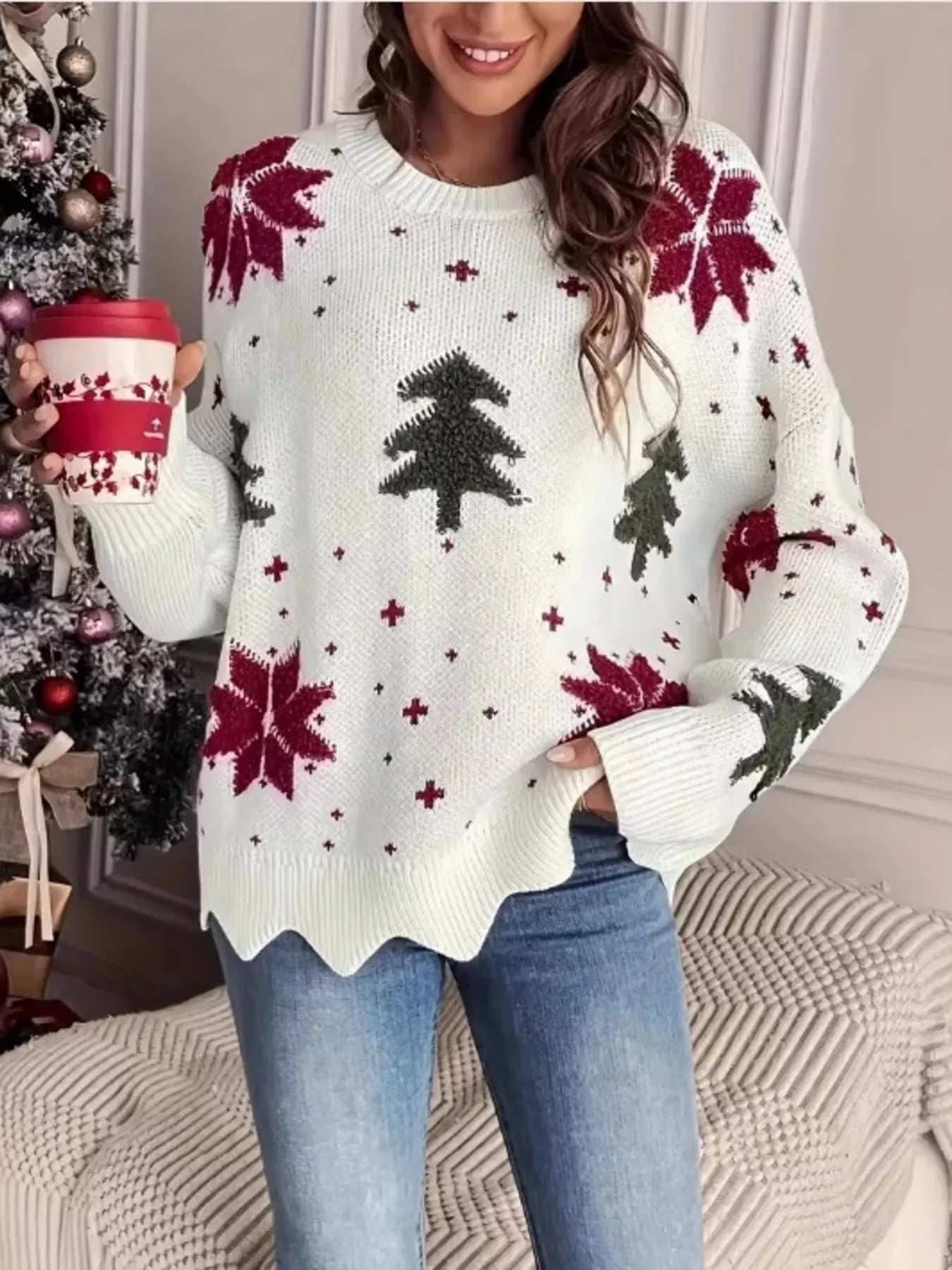 Festive knit sweater with Christmas trees and poinsettia design styled with jeans for winter outfit.