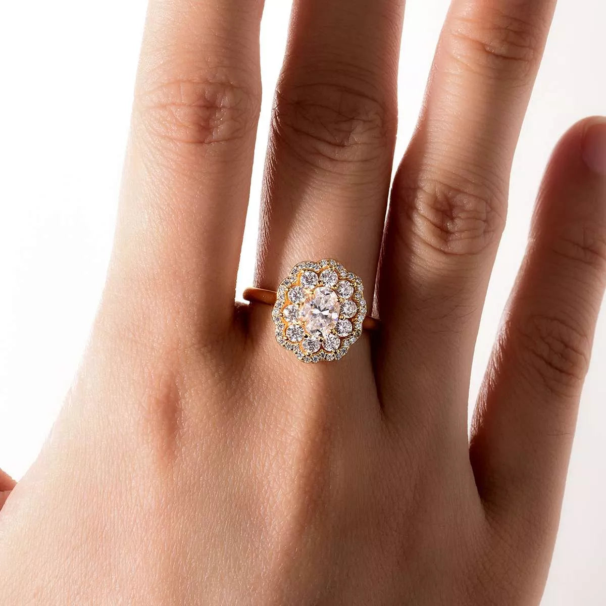 Gold-plated floral halo moissanite ring with oval center stone and layered petals of sparkling gems.