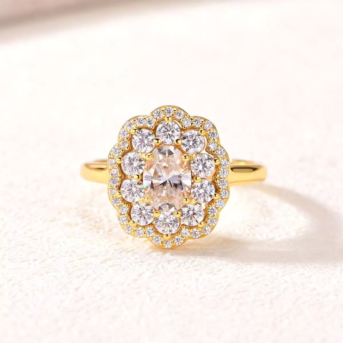 Gold-plated floral halo moissanite ring with oval center stone and layered petals of sparkling gems.
