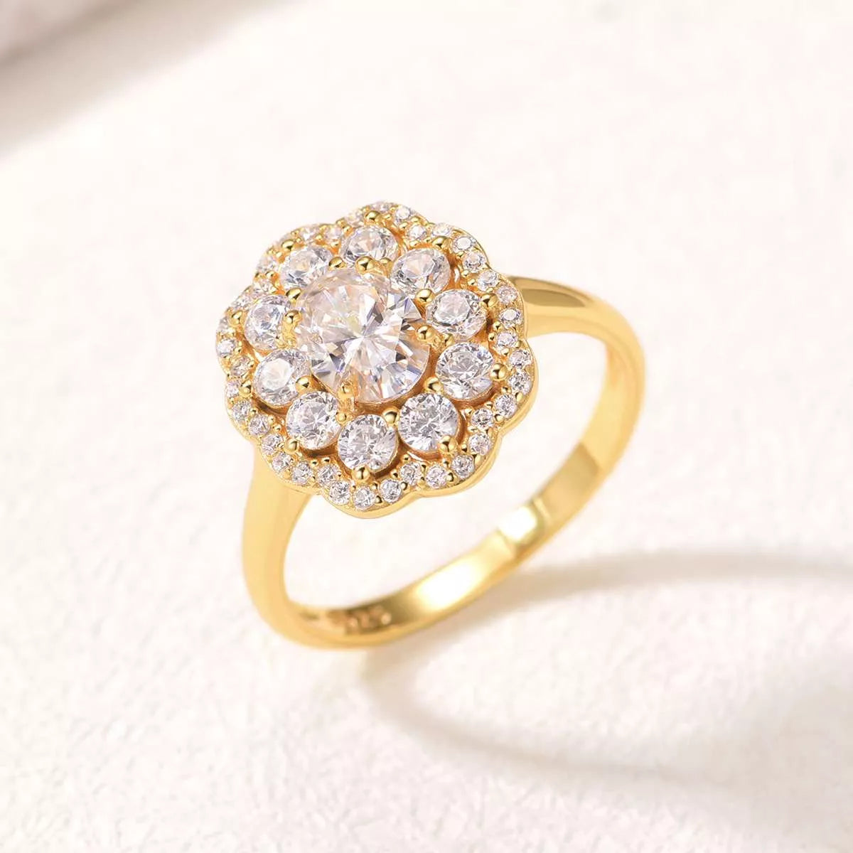 Gold-plated floral halo moissanite ring with oval center stone and layered petals of sparkling gems.
