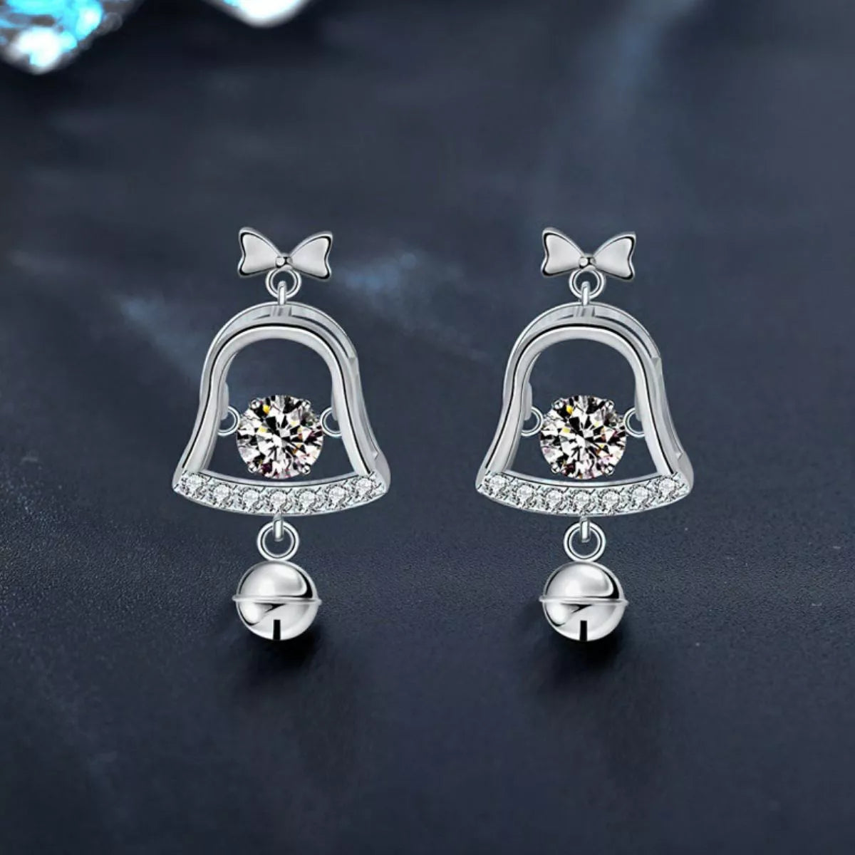 Pair of platinum-plated sterling silver bell earrings with 0.5ct moissanite center stones and dangling jingle bells.