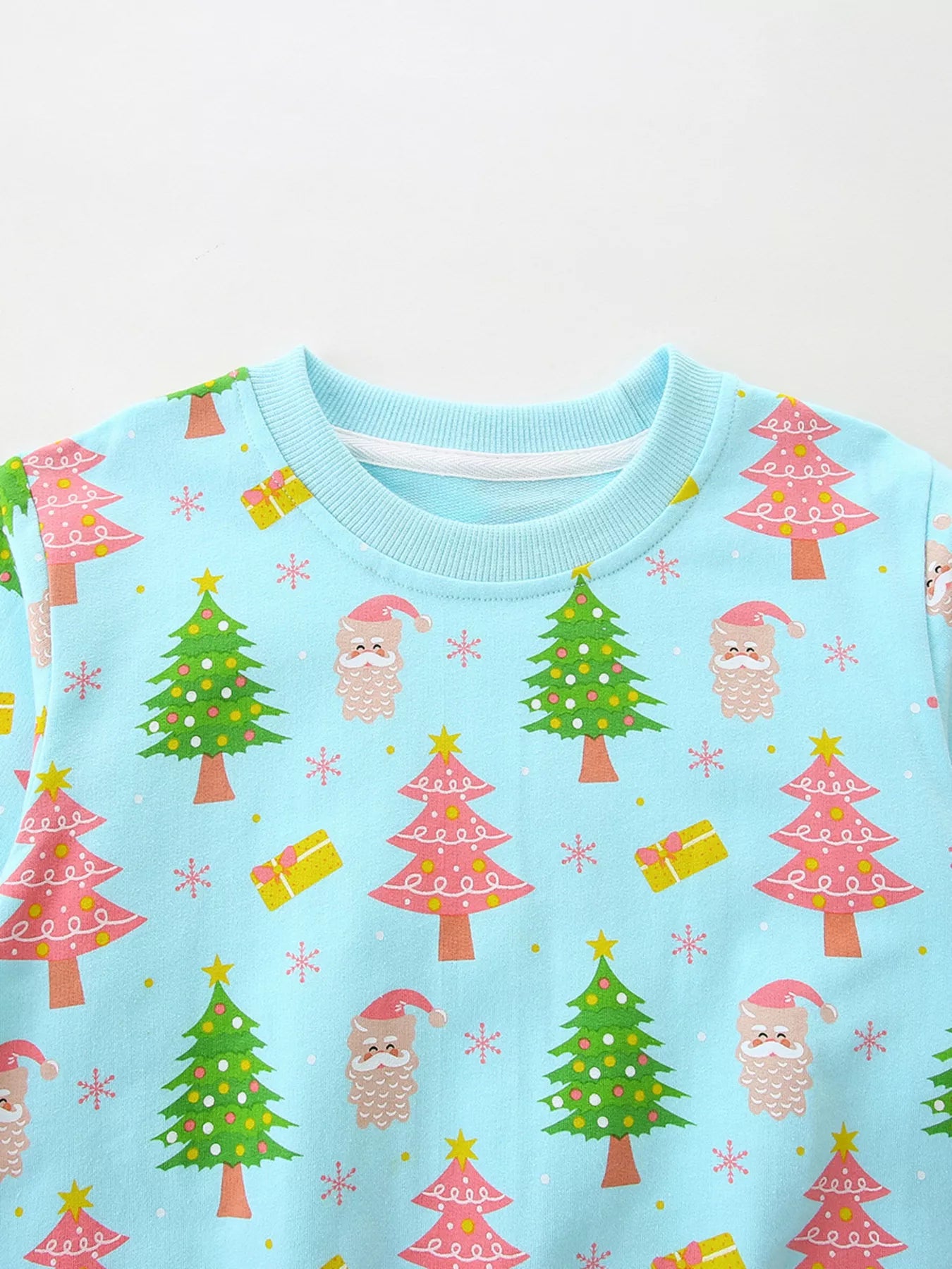 A light blue kids sweatshirt decorated with Santa faces, Christmas trees, and gift illustrations for a festive holiday look.