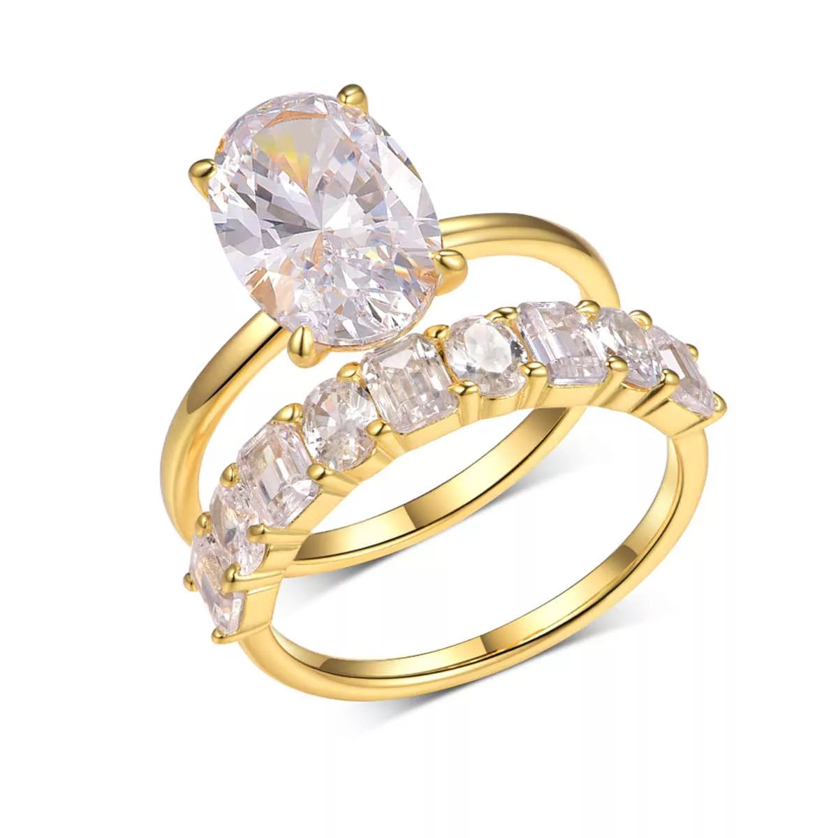 Gold two-piece oval moissanite ring set with eternity band inlaid with emerald and round cuts — elegant bridal jewelry from A Whimsical Affair.