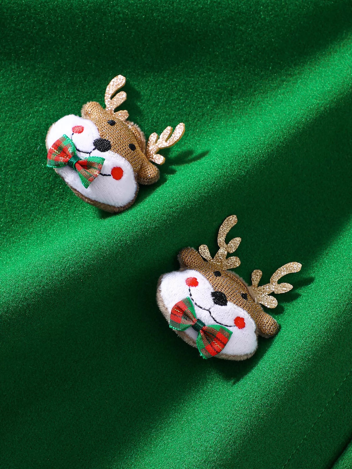 Green Christmas hooded cape for kids with “MERRY” embroidery and reindeer appliqués, pom-trim hem, displayed on holiday background.