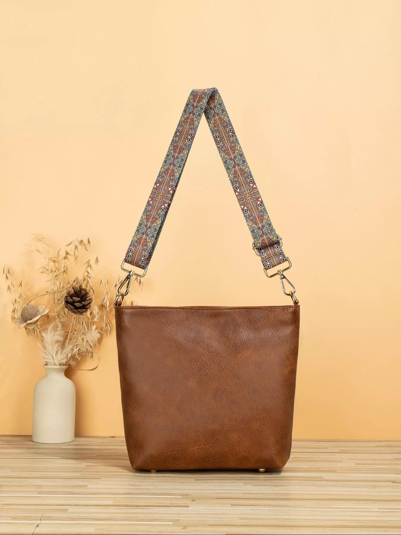 Medium PU leather tote bag with wide patterned mosaic strap and structured silhouette.
